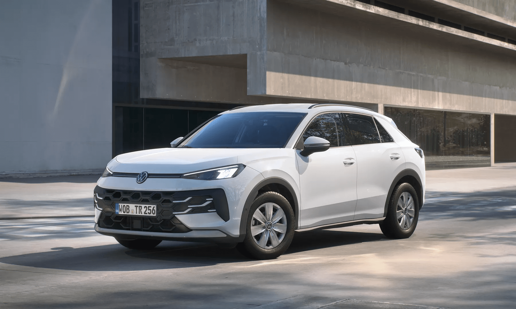 Valge Volkswagen T-Roc Trend seisab moodsa hoone ees.