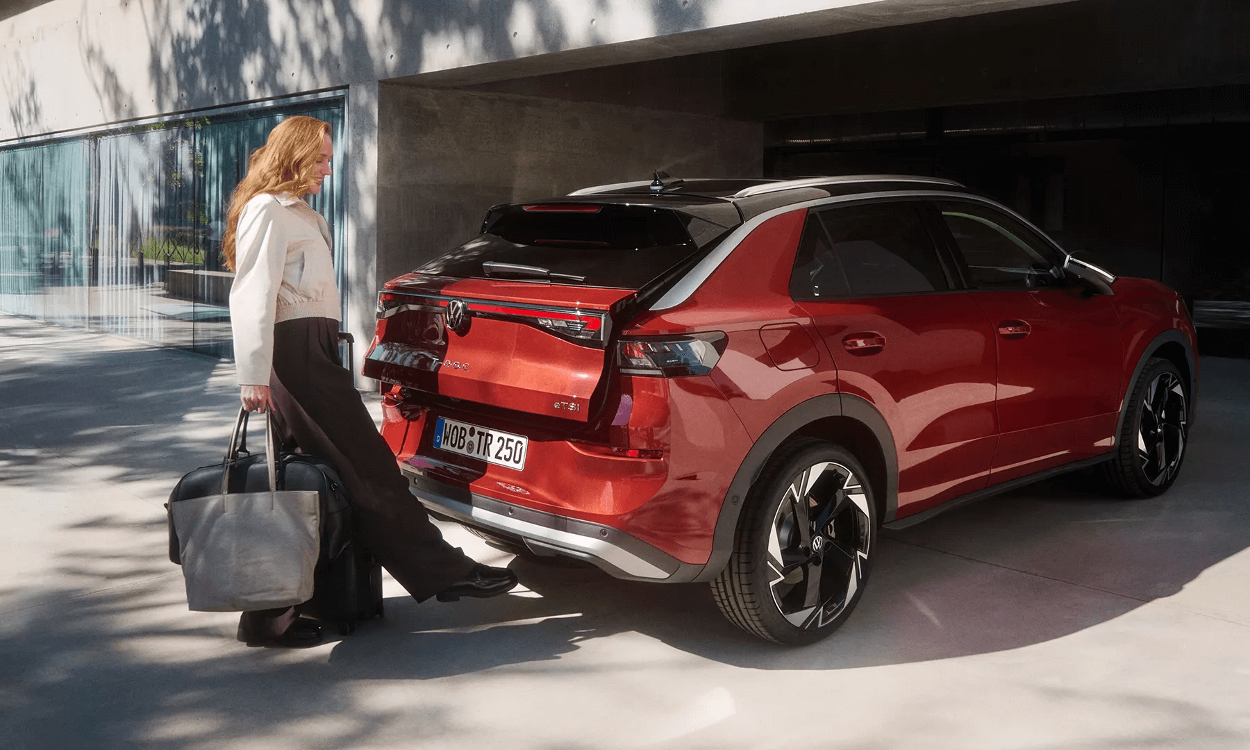 Naine avab punase Volkswagen T-Roc pagasiruumi ilma käsi kasutamata.