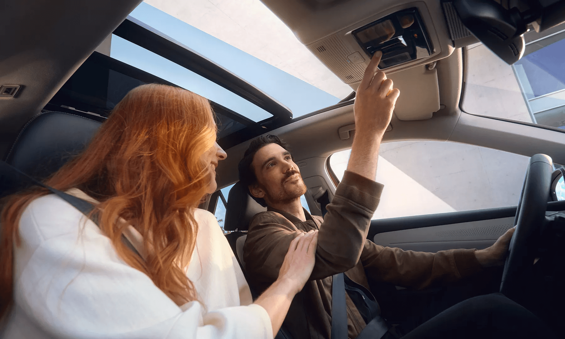 Paar autos koos avatud panoraamkatusega ja päikeselise taevaga.