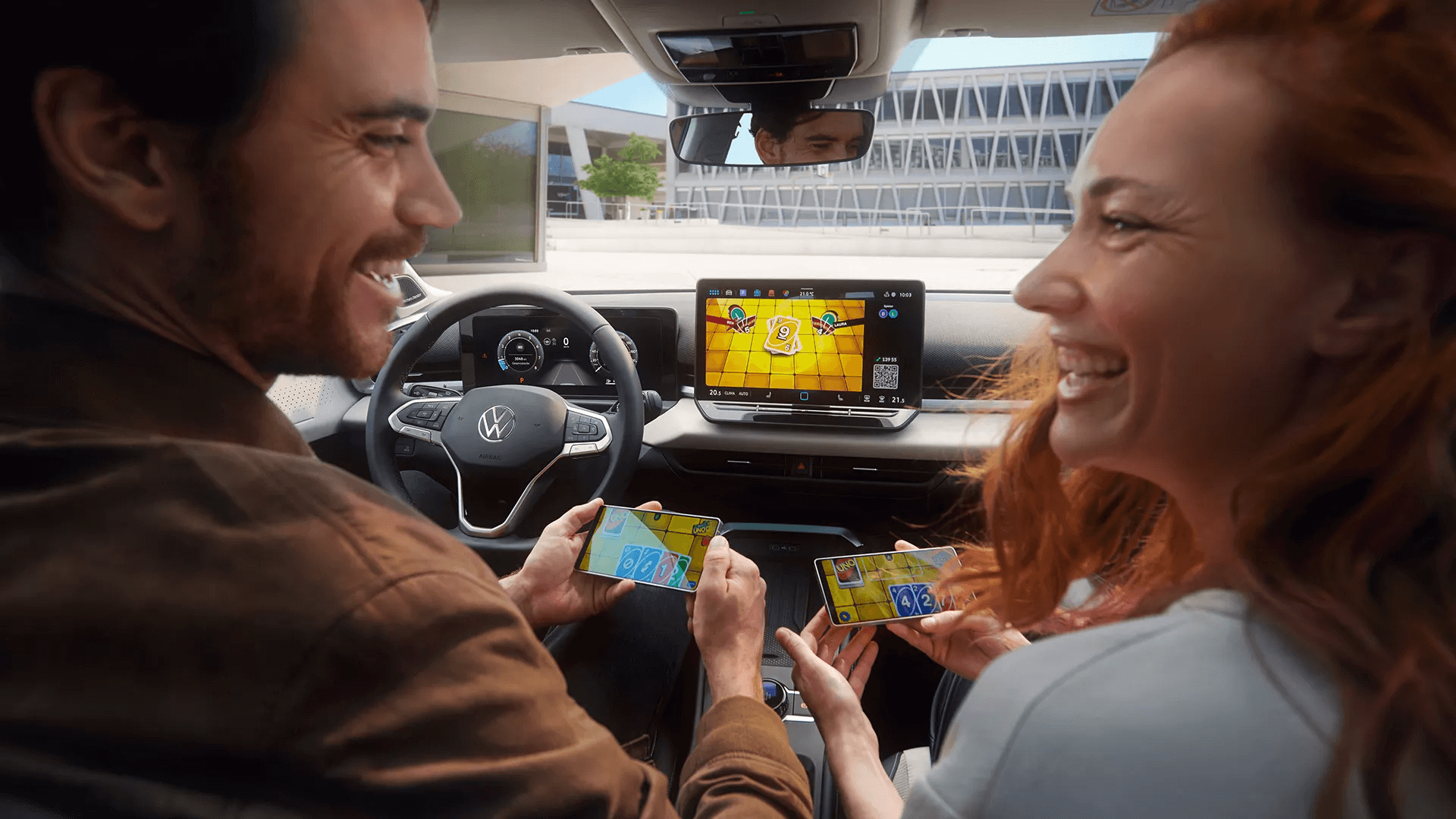 Paar mängib oma telefonides mängu, kasutades Volkswagen T-Roc ekraani.
